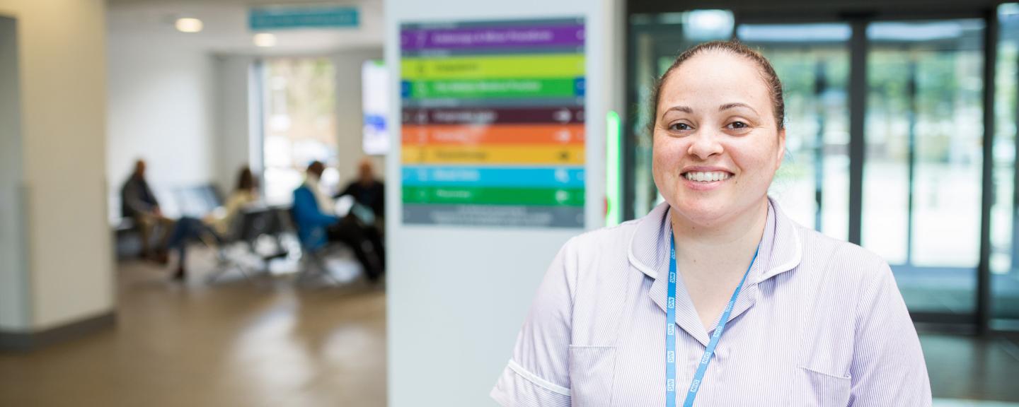 A nurse smiling at the camera in a hospital 