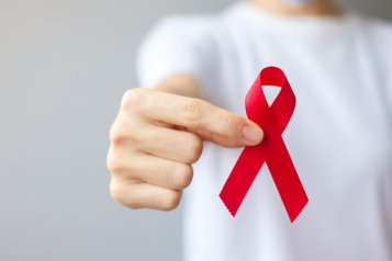 person holding a red ribbon for world blood cancer day